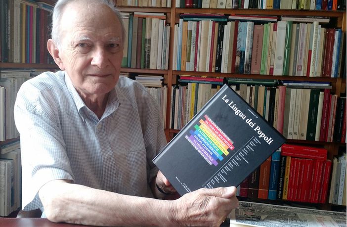 Mario Coda ritratto nel suo studio accanto agli atti del secondo convegno linguistico di Su Nuraghe