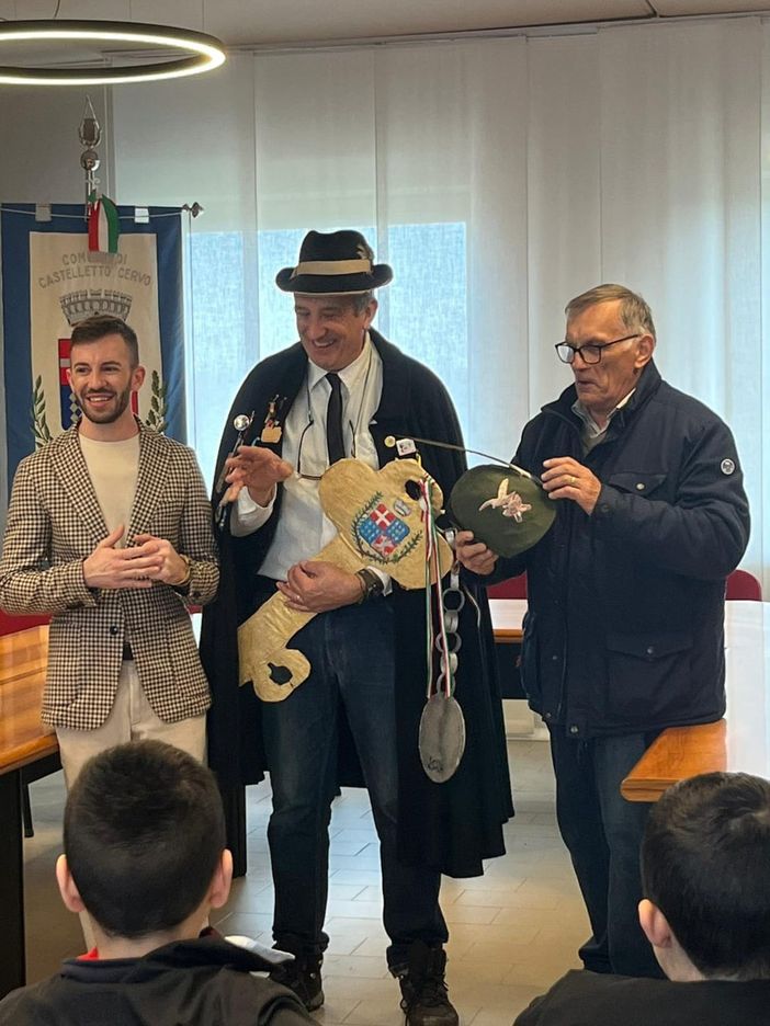 Castelletto Cervo, gli alunni della primaria consegnano la chiave del paese al "Raspet", con un cappello da Alpino, foto pag fb
