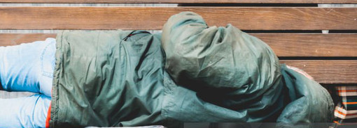 Vedono un uomo dormire a terra in un sacco di plastica e avvertono il 112