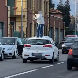 Sale sul tetto dell'auto e si denuda, caos in via Milano a Vigliano