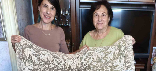 Nell’immagine, Sebastiana Vittoria Nurra con la figlia Alba mostra un antico pizzo a filet donato al Museo di Pettinengo. Nell’immagine, Sebastiana Vittoria Nurra con la figlia Alba mostra un antico pizzo a filet donato al Museo di Pettinengo.