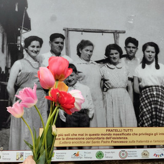 Gigantografia di migranti esposta sui muri demaniali di Pettinengo e tulipani coltivati dai richiedenti asilo dell’Associazione Pacefuturo, distribuiti da Piccola Fata in occasione del 25 aprile 2026 (foto M. Rebuffa).